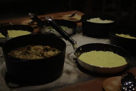 Traditionelles brasilianisches Gericht in schwarzen Töpfen serviert, begleitet von Polenta und weiteren Beilagen.